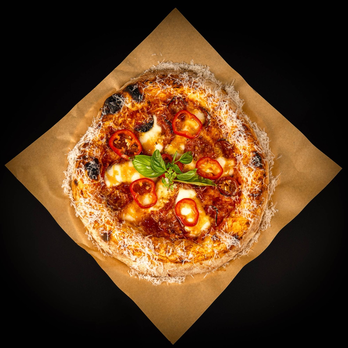 A wood-fired Bravado pizza with red peppers, basil and grated cheese